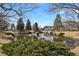 Scenic view of a pond framed by trees, featuring serene water and green foliage at 14001 E Marina Dr # 603, Aurora, CO 80014