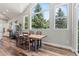 Dining area with wood flooring, a large wood table, and large picture windows offering backyard views at 6532 S Tempe St, Aurora, CO 80016