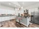 Modern kitchen with stainless steel appliances, island with seating, and custom backsplash at 6532 S Tempe St, Aurora, CO 80016