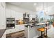 Bright kitchen features stainless appliances, mosaic backsplash, dark countertops, island with bar seating, and pendant lights at 6532 S Tempe St, Aurora, CO 80016
