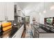 Open kitchen showcases stainless appliances, mosaic backsplash, dark countertops, undermount sink, and view to the living room at 6532 S Tempe St, Aurora, CO 80016