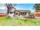 Relaxing backyard featuring a spacious deck with a pergola, green grass, and mature trees, perfect for outdoor enjoyment at 540 Columbine Ave, Broomfield, CO 80020