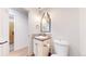 Powder room featuring a pedestal sink, decorative mirror, and a view into the adjacent room at 540 Columbine Ave, Broomfield, CO 80020