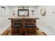 Stylish basement bar with wooden countertop, leather stools, and unique aviation-themed decor at 25049 E Alder Dr, Aurora, CO 80016