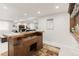 Finished basement bar featuring a sink, storage, and an adjacent seating area for entertaining at 25049 E Alder Dr, Aurora, CO 80016