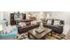Open-concept basement with leather sofas, a large coffee table, and a full entertainment center at 25049 E Alder Dr, Aurora, CO 80016