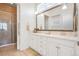 Bathroom with double vanity, large mirror, tiled shower, and neutral decor at 25049 E Alder Dr, Aurora, CO 80016