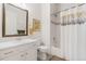 Well-lit bathroom featuring a vanity with sink, toilet, and shower-tub combo with patterned curtain at 25049 E Alder Dr, Aurora, CO 80016