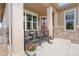 Charming covered front porch with seating and decorative potted flowers, perfect for relaxing at 25049 E Alder Dr, Aurora, CO 80016