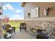 Outdoor patio features wicker furniture with navy cushions and attractive floral decorations and stone accents at 25049 E Alder Dr, Aurora, CO 80016