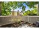 Cozy backyard patio area with a white picket fence providing privacy and lots of green foliage at 2826 S Lansing Way, Aurora, CO 80014