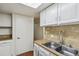 The kitchen features stainless steel sink, neutral backsplash, and wood look flooring at 2826 S Lansing Way, Aurora, CO 80014
