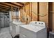 Unfinished basement laundry area with a washer and dryer hookups exposed, utility installations, and concrete flooring at 2826 S Lansing Way, Aurora, CO 80014