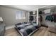 Bedroom with hardwood floors, a bright window, and an open closet with clothes inside at 10115 W 25Th Ave # 1, Lakewood, CO 80215