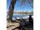 Pictured is a young sitting on a log by the lake enjoying the outdoors on a sunny day at 10115 W 25Th Ave # 1, Lakewood, CO 80215
