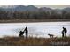 People walking at Crown Hill Park, enjoying the serene water views, with mountain backdrop at 10115 W 25Th Ave # 1, Lakewood, CO 80215