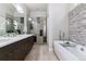 Spa-like bathroom with double vanity, shower, and freestanding tub at 3444 Mariposa St, Denver, CO 80211