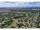 Aerial view showcasing a well-planned community with lush green spaces, walking trails, and a serene lake at 3419 Traver Dr, Broomfield, CO 80023