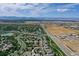 Houses dot the landscape near a pond and open fields in this aerial neighborhood view at 3419 Traver Dr, Broomfield, CO 80023