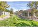 Spacious backyard with manicured lawn, garden, and a charming sunroom attached to the home at 3419 Traver Dr, Broomfield, CO 80023