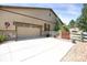 Spacious two-car garage with extended driveway and tasteful landscaping on a sunny day at 3419 Traver Dr, Broomfield, CO 80023