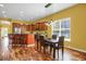 Open-concept kitchen with breakfast bar flows into dining area featuring hardwood floors at 3419 Traver Dr, Broomfield, CO 80023