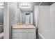 Well-lit bathroom features a vanity, a wide mirror, and a shower tub with curtain at 5229 Nighthawk Pkwy, Brighton, CO 80601