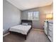 This bedroom features soft carpet, a window, and a sleek black queen bed at 5229 Nighthawk Pkwy, Brighton, CO 80601
