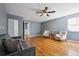 Living area featuring wood floors, soft grey walls, and a ceiling fan with lights at 5229 Nighthawk Pkwy, Brighton, CO 80601
