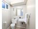 Well-lit bathroom featuring a clean toilet and sink with a large mirror at 5460 E Bails Dr, Denver, CO 80222