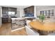 Open-concept kitchen and dining area featuring wood floors and breakfast bar at 5460 E Bails Dr, Denver, CO 80222