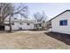 Spacious backyard featuring an outdoor seating area, mature trees, and white brick house elevation at 965 S Jersey St, Denver, CO 80224