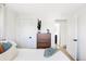 Bright bedroom featuring white walls, wood dresser, and ample natural light from a nearby door at 965 S Jersey St, Denver, CO 80224