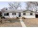 Charming single-story home featuring painted brick, a modern front door and a well-manicured front yard at 965 S Jersey St, Denver, CO 80224