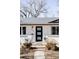 Close-up view of the front porch with a modern black front door and brickwork facade at 965 S Jersey St, Denver, CO 80224