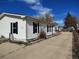 Charming single-story home features white siding, blue shutters, and a well-maintained front yard at 311 Elm St, Lochbuie, CO 80603