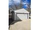 Detached white garage with a large driveway, offering ample parking space at 311 Elm St, Lochbuie, CO 80603