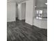Open-concept living room with modern gray wood floors flows into the kitchen area at 311 Elm St, Lochbuie, CO 80603