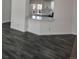 Open-concept living room featuring gray wood-look flooring and a breakfast bar at 311 Elm St, Lochbuie, CO 80603