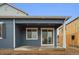 The exterior of a modern, blue house featuring a covered patio with a sliding glass door entrance at 6566 N Nepal St, Aurora, CO 80019