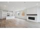 Open-concept living room with kitchen, fireplace, large windows, and wood floors at 6566 N Nepal St, Aurora, CO 80019