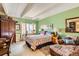 This cozy bedroom features green walls, a floral quilt, and a comfortable armchair at 7865 E Mississippi Ave # 304, Denver, CO 80247