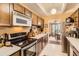 Galley kitchen featuring classic cabinets and appliances at 7865 E Mississippi Ave # 304, Denver, CO 80247