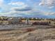 A wide view of the community with the recreation center, grassy hills, and a cloudy blue sky at 3367 New Haven Cir, Castle Rock, CO 80109