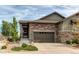 Home exterior featuring a stone facade, two car garage, and well manicured landscaping at 3367 New Haven Cir, Castle Rock, CO 80109