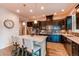 Modern kitchen featuring an island with seating, dark cabinetry, and stainless steel appliances at 3367 New Haven Cir, Castle Rock, CO 80109