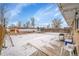 Large backyard featuring snow-covered concrete patio, fence, and shed at 1281 Myrtle St, Brighton, CO 80601