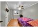 This cute bedroom boasts a ceiling fan, wood floors, and a window with natural light at 1281 Myrtle St, Brighton, CO 80601