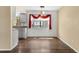 Bright dining area with hardwood floors, modern light fixture, and a window with decorative red swag at 6730 W 84Th Cir # 96, Arvada, CO 80003