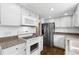 Bright kitchen featuring white cabinets, granite countertops, and stainless steel appliances at 6730 W 84Th Cir # 96, Arvada, CO 80003